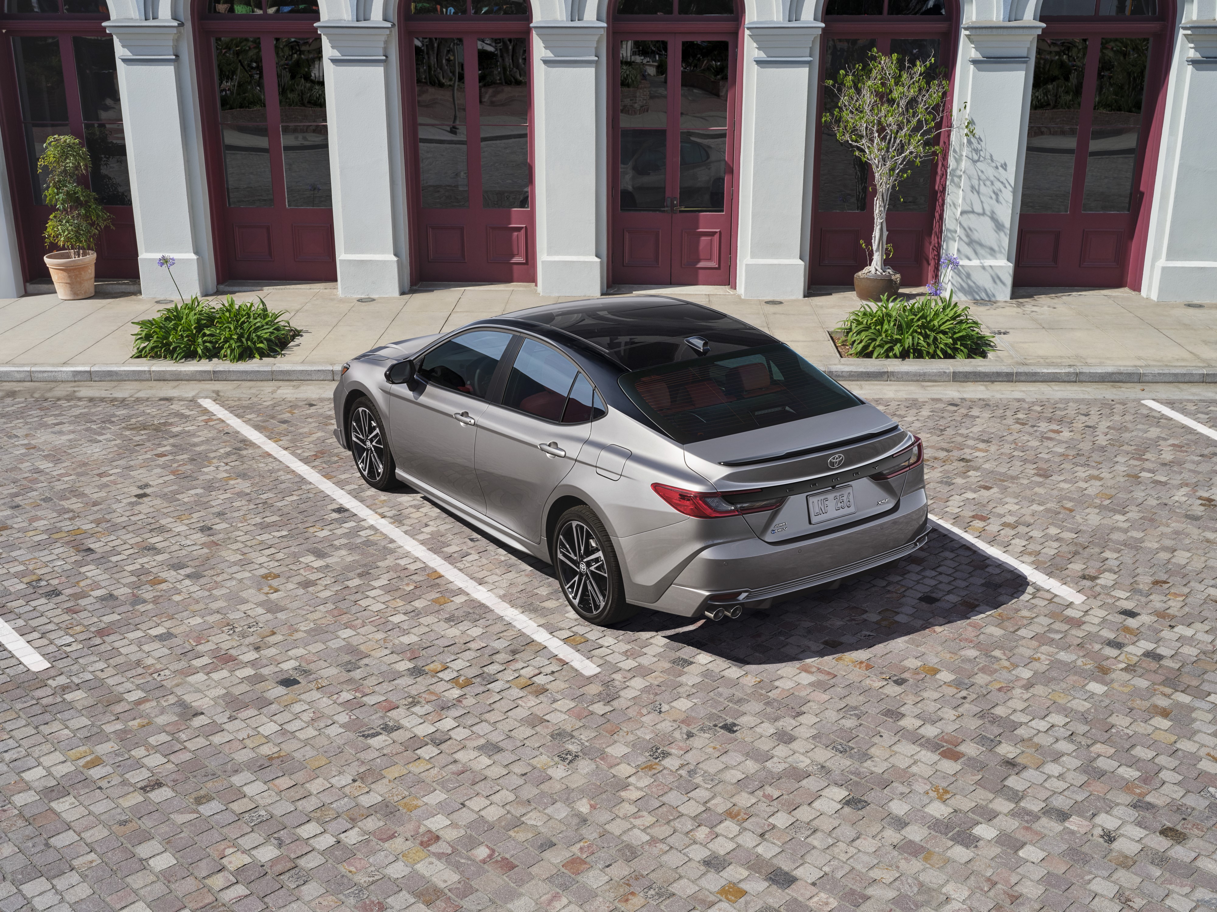 2025 Toyota Camry XSE in Celestial Silver with Jet Black Roof parked in front of landmark