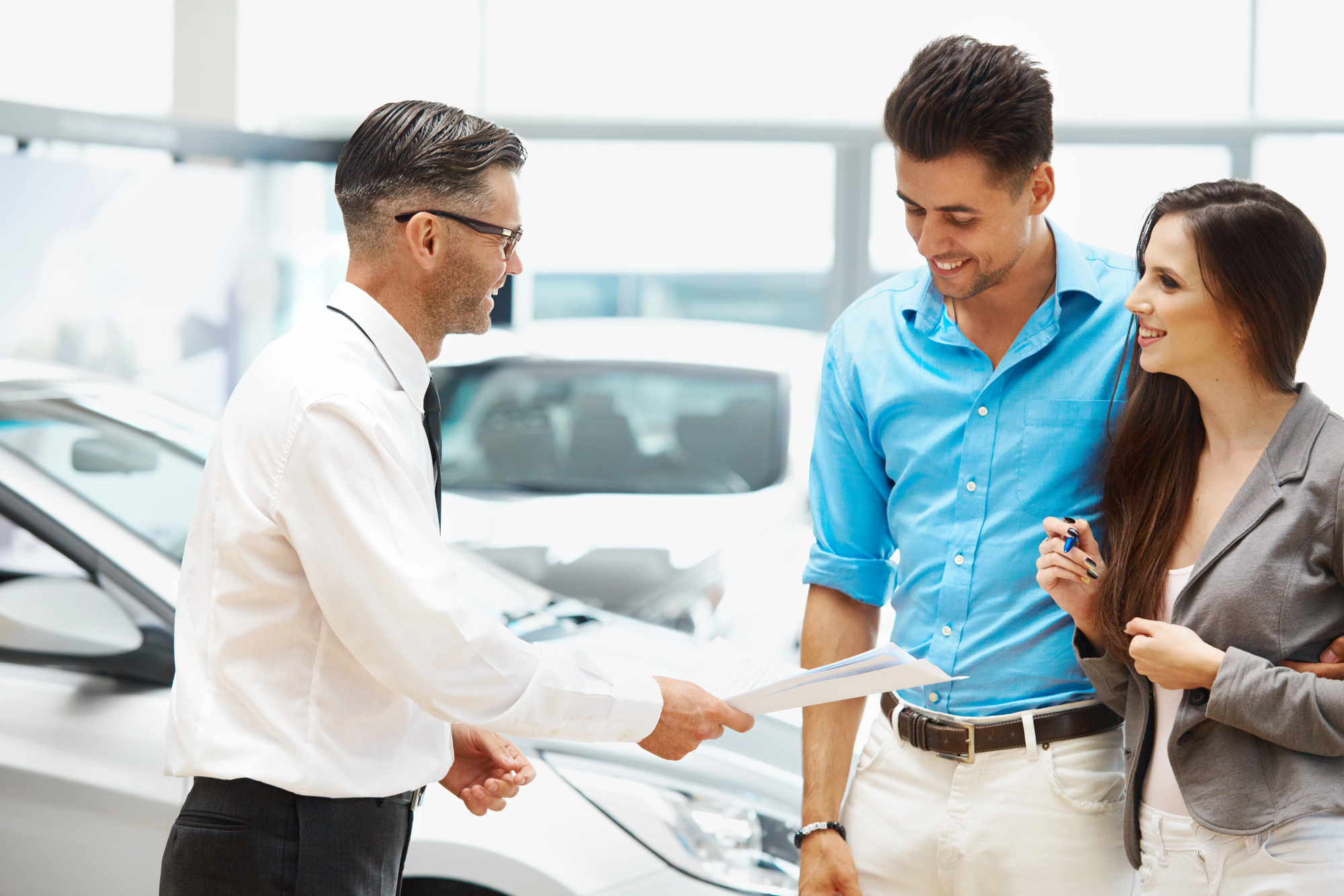 car dealer giving a young couple a price quote